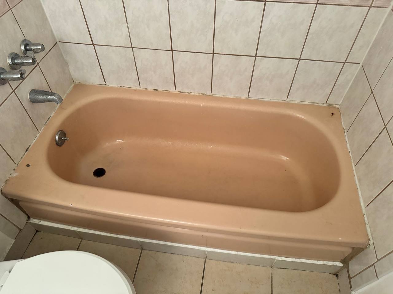 Outdated beige bathtub with worn finish before Los Angeles refinishing