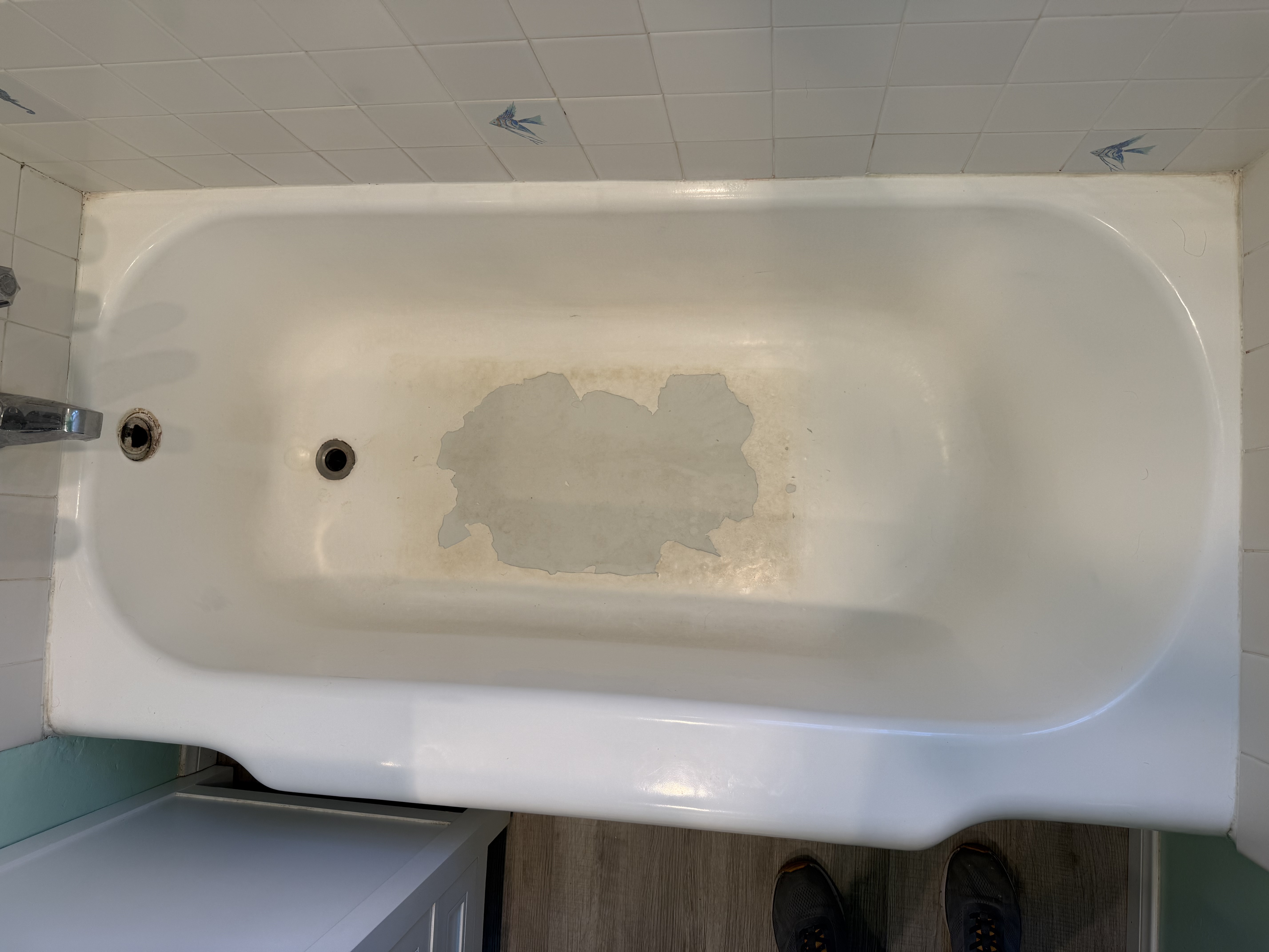 Sanding and preparing the cast iron bathtub surface for refinishing